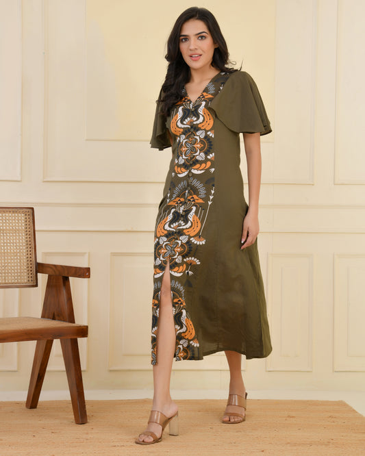 Woman wearing an olive green A-line midi dress with bold floral and bird print and flared cape sleeves